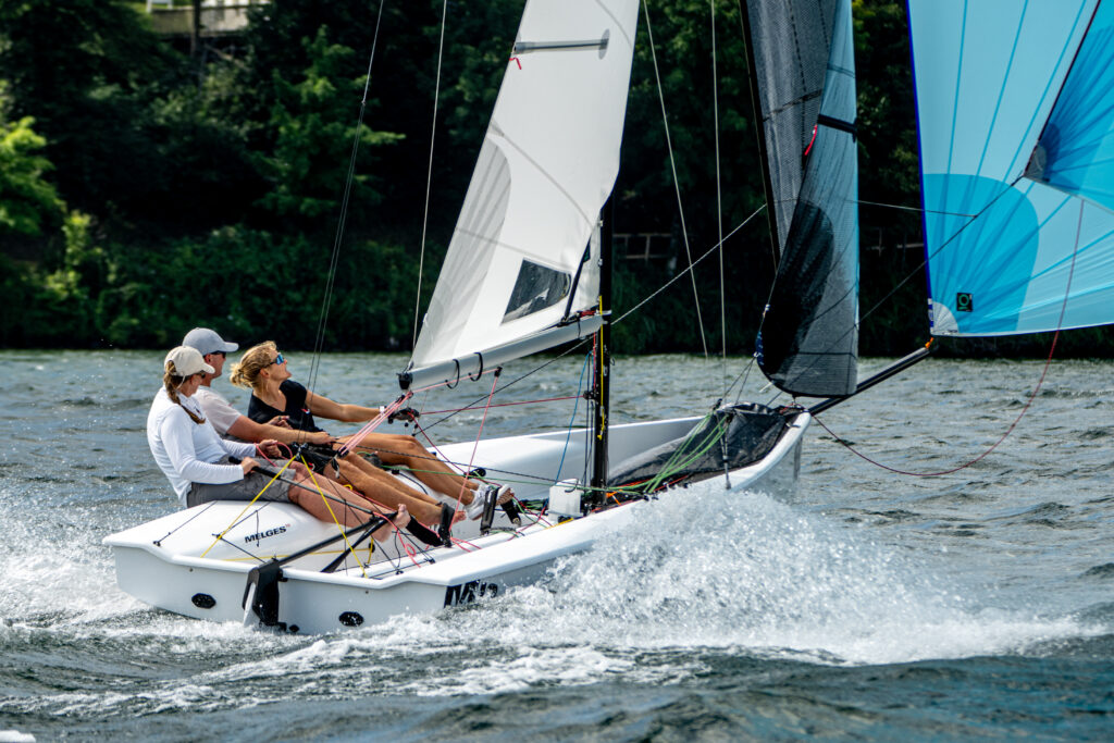 Melges 19 dinghy sailing fast under spinnaker.