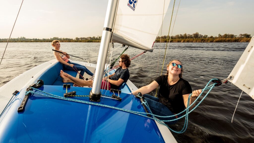3 people on a sailboat